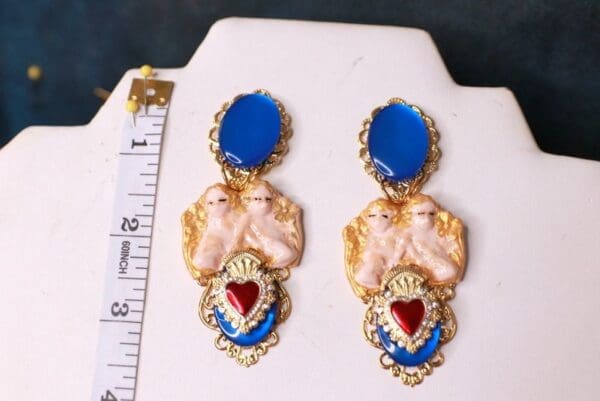 A pair of earrings with blue and red accents.