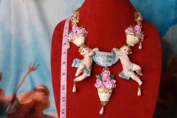 A necklace with cherubs and flowers on it