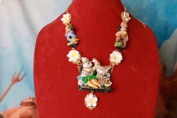A red display with a necklace and some flowers