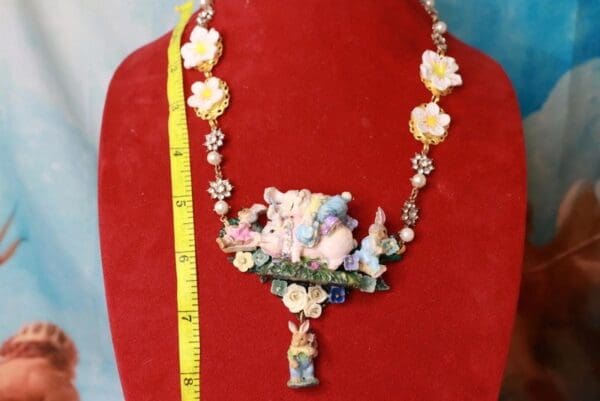 A red display with a necklace and a yellow measuring tape.