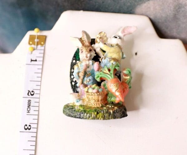 A small statue of rabbits and bunnies on the side of a table.
