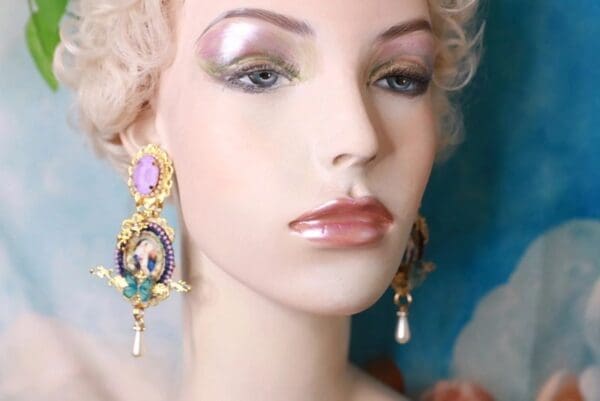 A mannequin wearing earrings with pearls and gold.