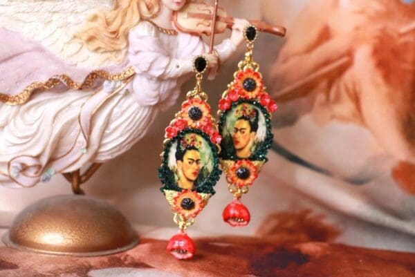 A pair of earrings with a picture of frida kahlo.