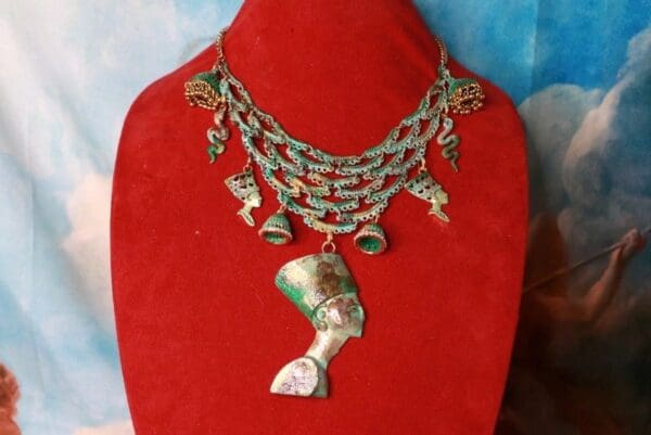 A red display with a necklace and some gold jewelry