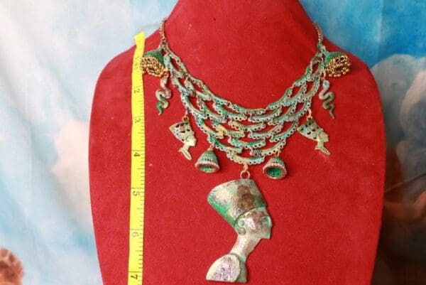 A red mannequin with a necklace and measuring tape.