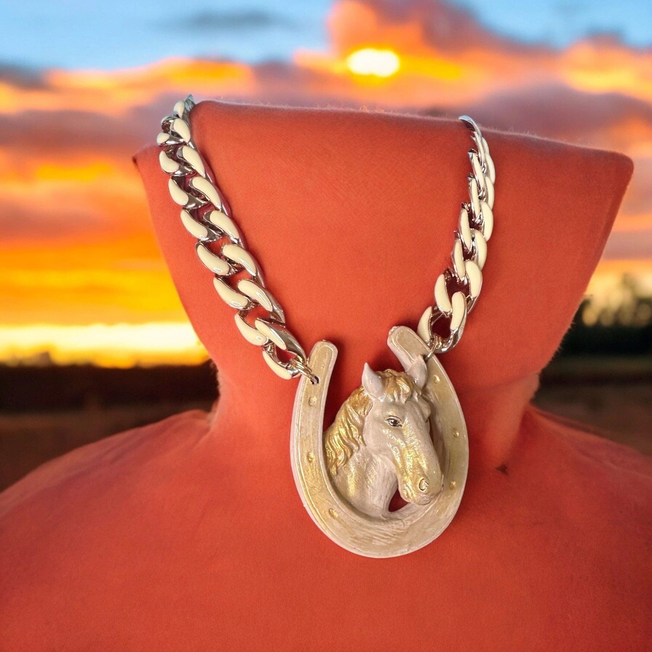A horse shoe necklace on top of an orange bust.