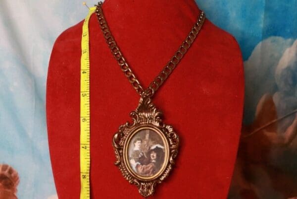 A red necklace with a picture of two people in it
