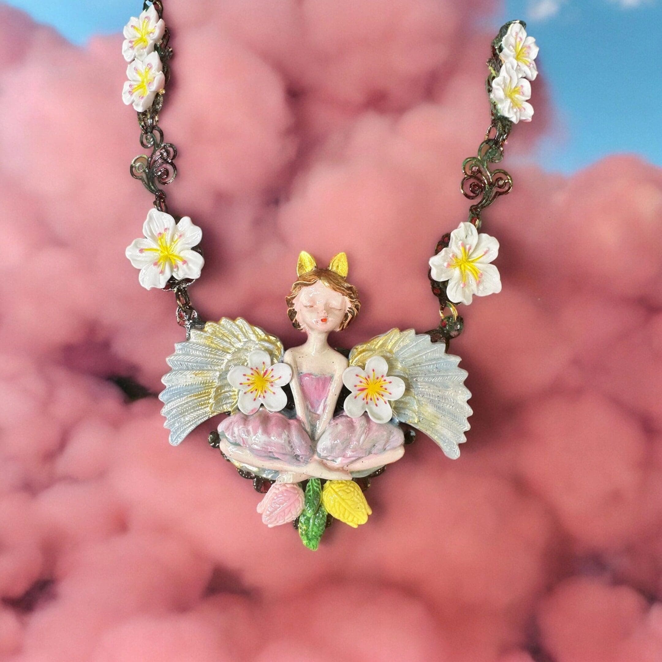 A necklace with flowers and a fairy on it.