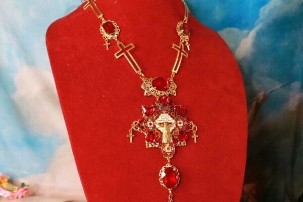 A red necklace with a cross and other crosses on it.