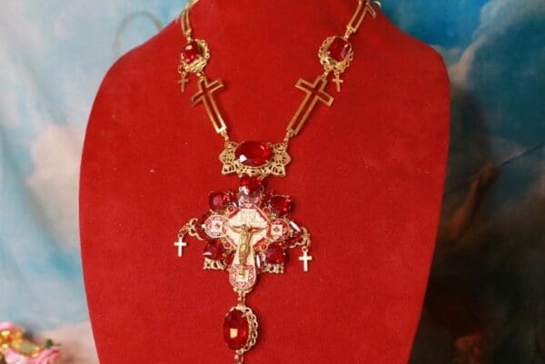 A red necklace with a cross and crucifix on it