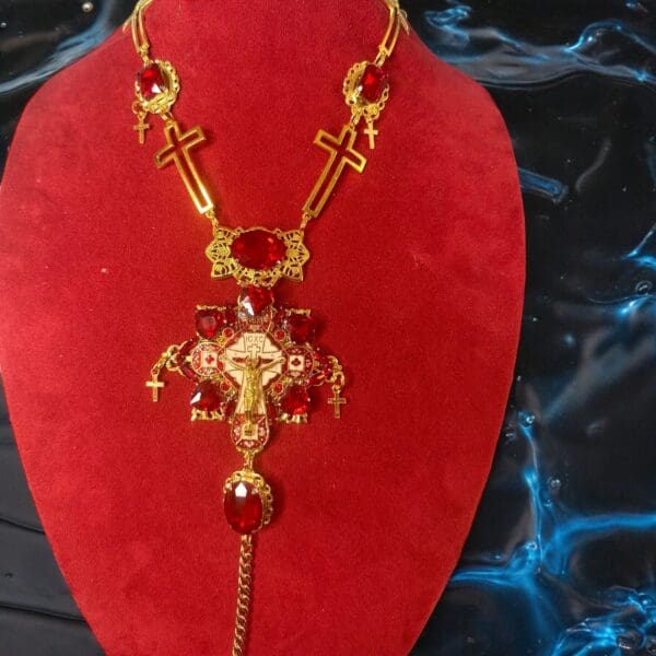 A red necklace with gold crosses and chains.