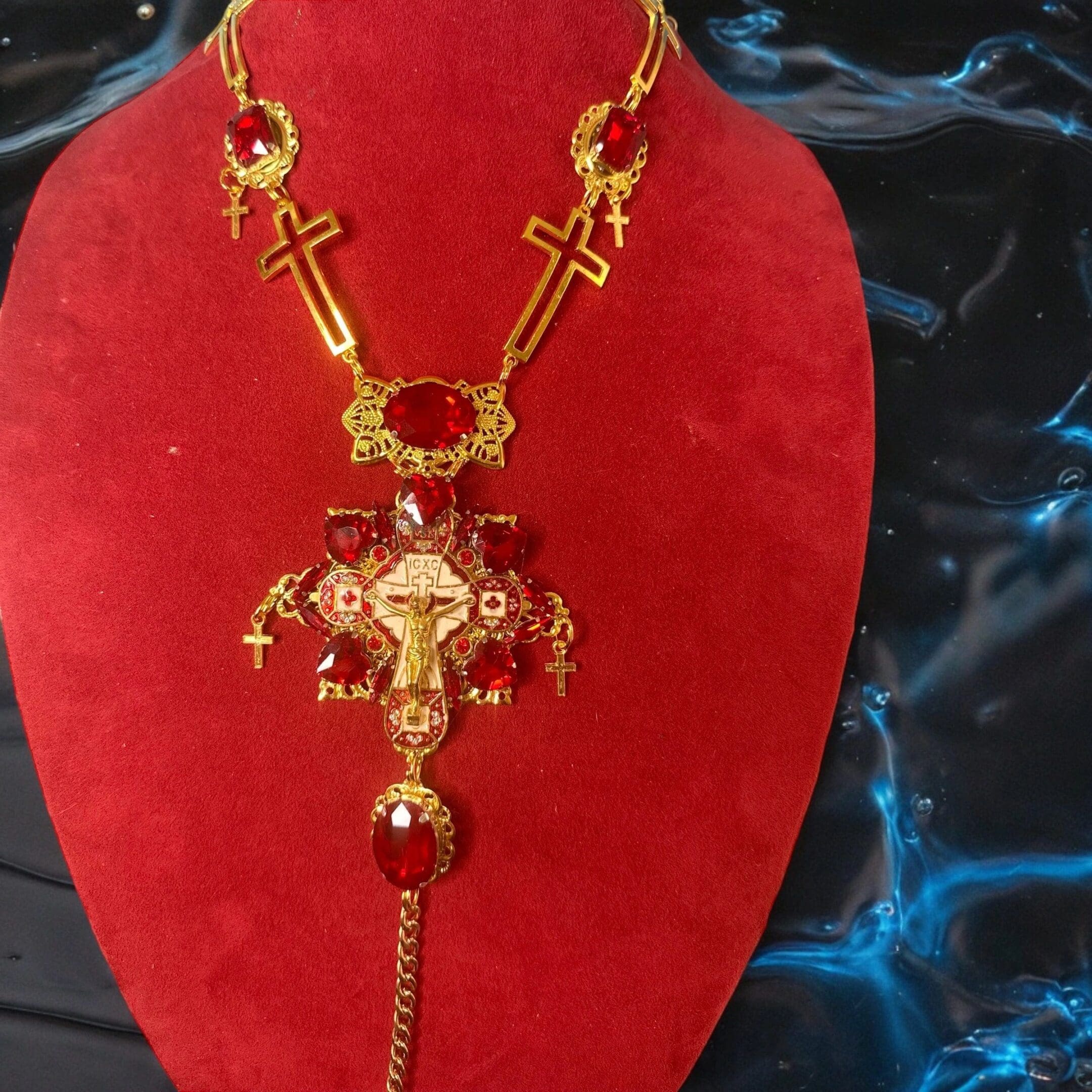 A red necklace with gold crosses and chains.