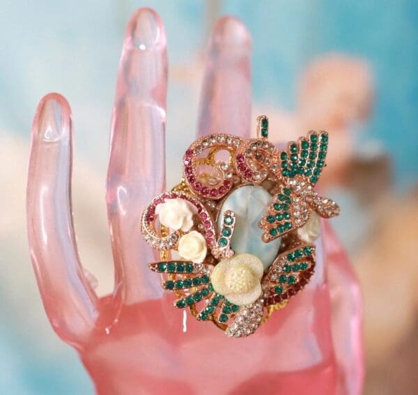A pink hand with some jewelry on it