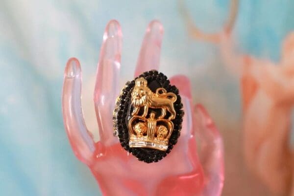 A hand holding a ring with a horse and rider on it.