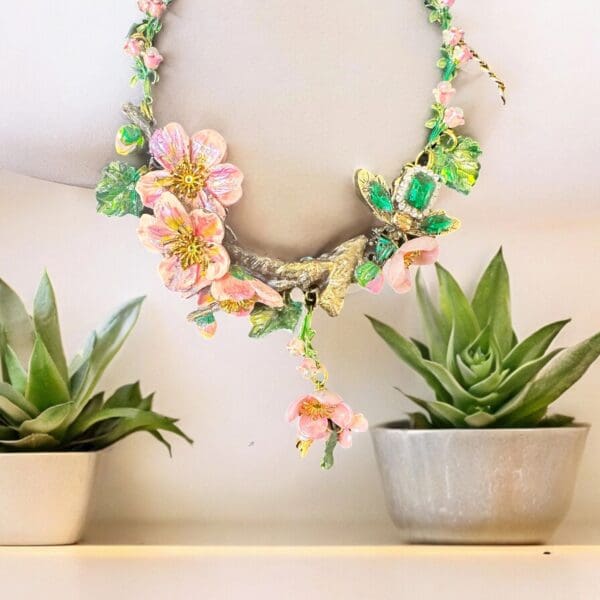A necklace made of paper and flowers hanging on the wall.