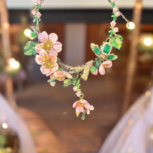 A necklace with flowers and leaves hanging from it.