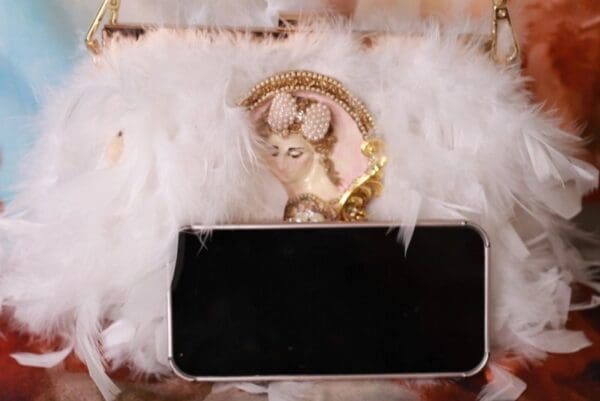 A cat is sitting on top of a phone.