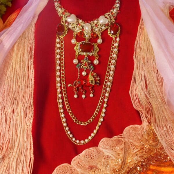 A red dress with many necklaces on it