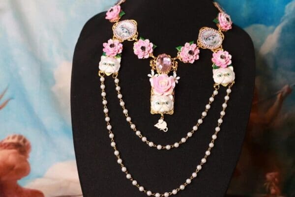 A necklace with pink flowers and pearls on it.
