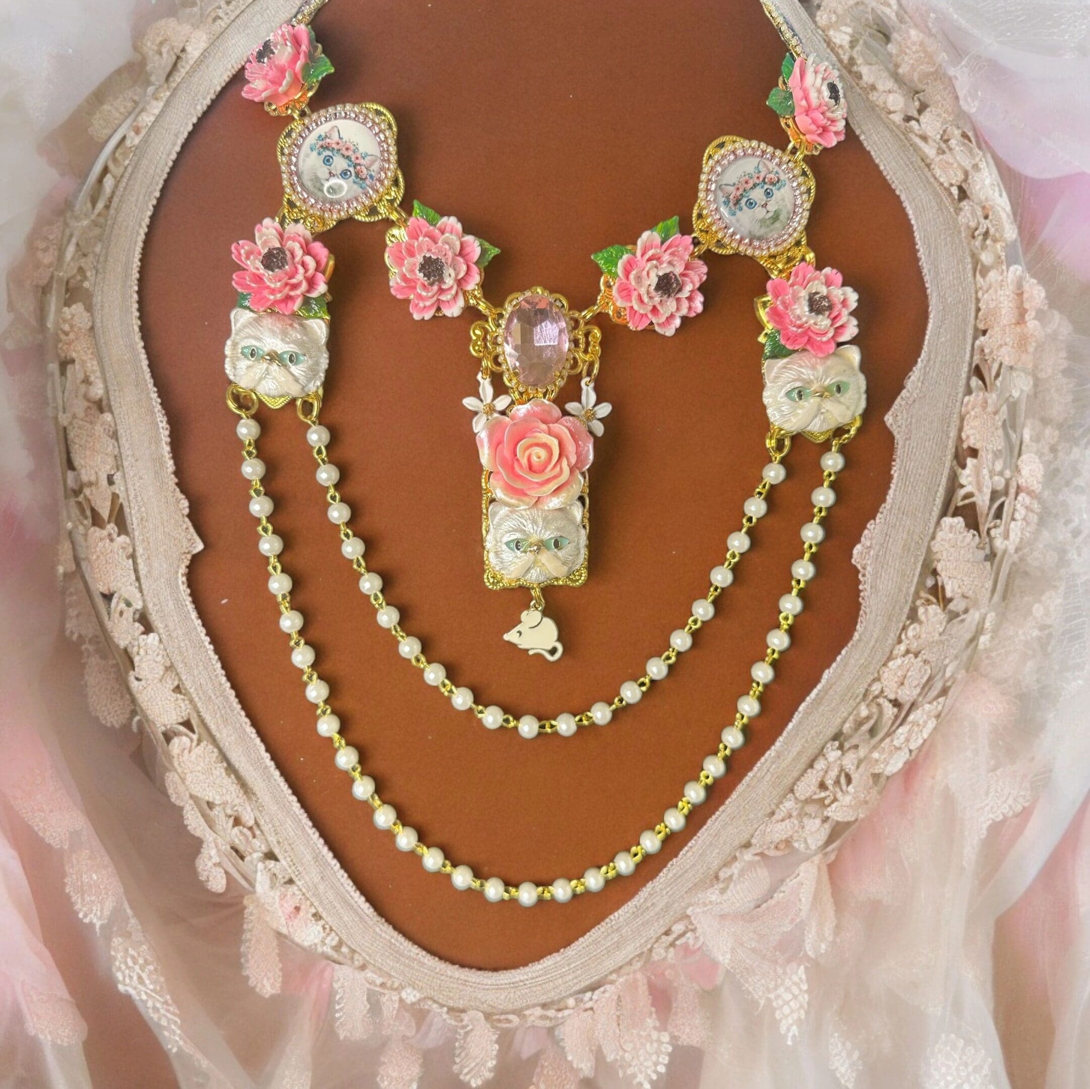 A necklace with pink flowers and pearls on it.