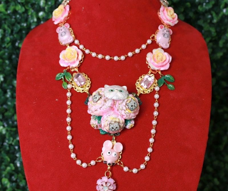 A red display stand with a necklace and cat brooch.
