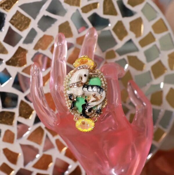A pink hand with a cartoon pin on it.