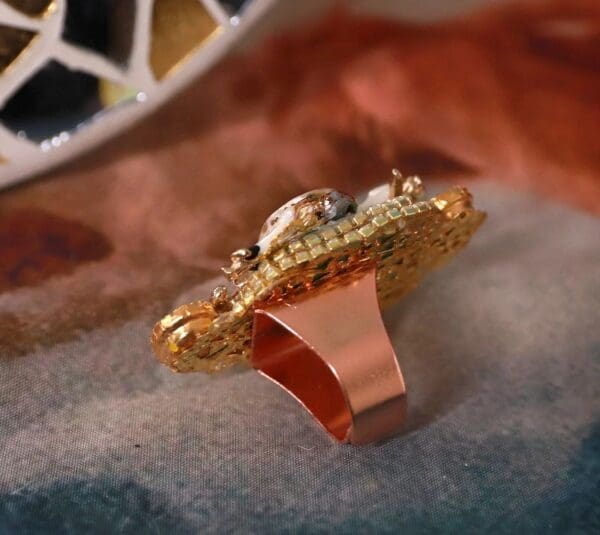 A gold ring with a diamond on top of it.