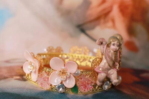 A close up of a bracelet with flowers and a figurine