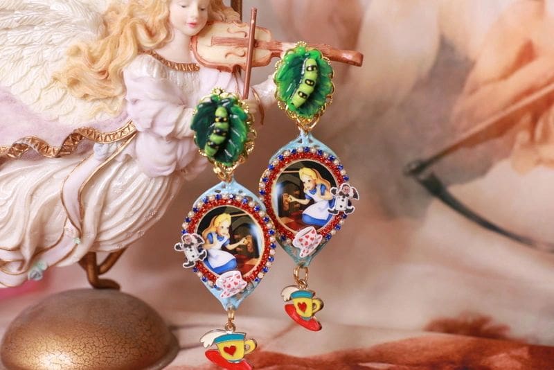A pair of earrings with an image of alice in wonderland.