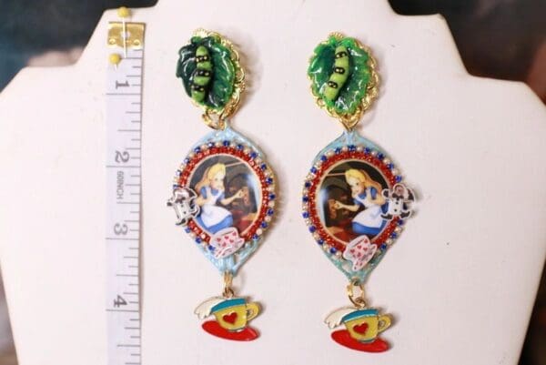 A pair of earrings with a picture and some other things
