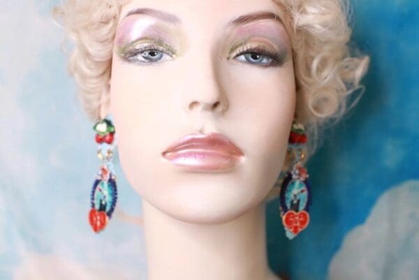 A mannequin wearing earrings with red and blue designs.