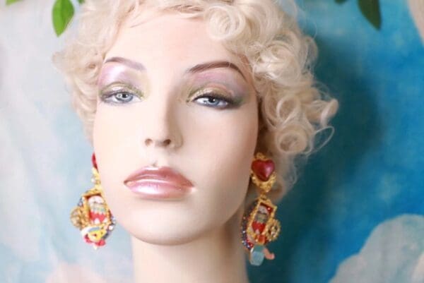 A mannequin with blonde hair and red earrings.