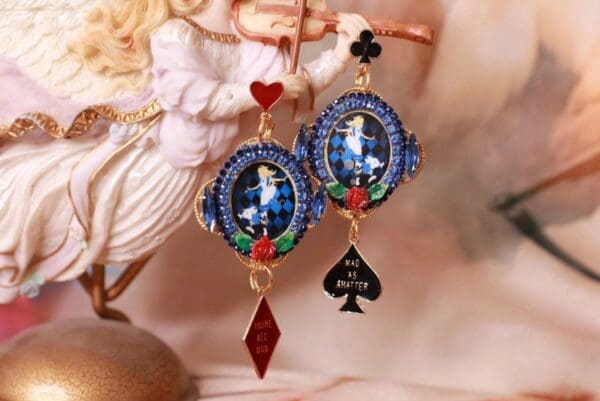 A pair of earrings with a picture and playing card.