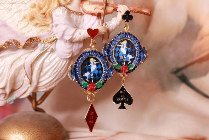 A pair of earrings with a picture and playing card.