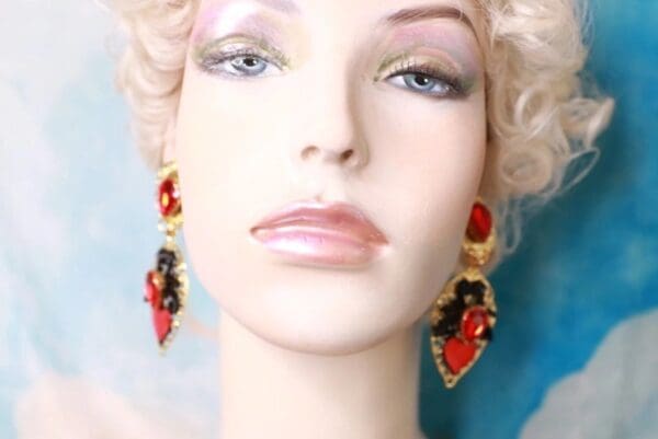 A mannequin wearing red and black earrings.