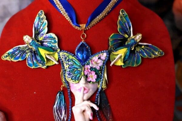 A close up of a necklace with a butterfly on it