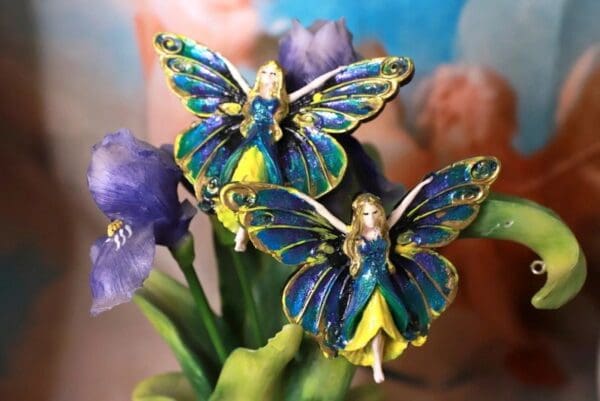 A close up of two blue and yellow fairy figurines