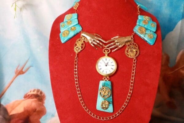 A red display case with a necklace and watch on it.