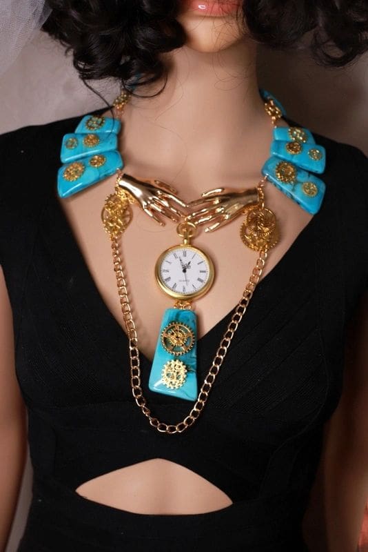 A woman wearing a necklace with chains and a clock.
