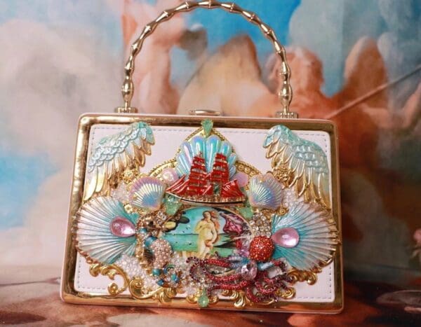 A purse with shells and a picture of the ocean.