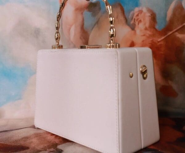 A white purse sitting on top of a table.