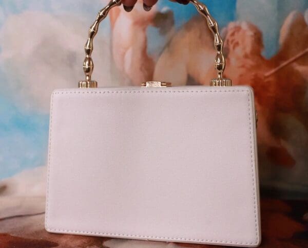 A white purse sitting on top of a table.