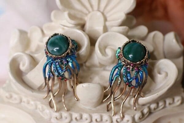 A pair of earrings with blue and green stones.