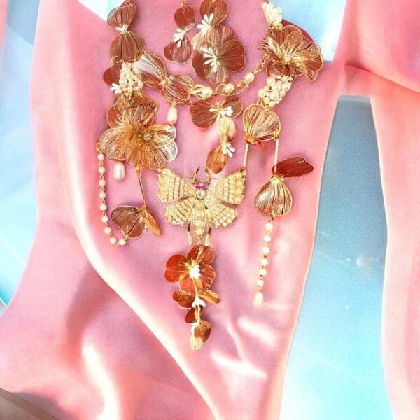 A pink dress with a butterfly necklace on it