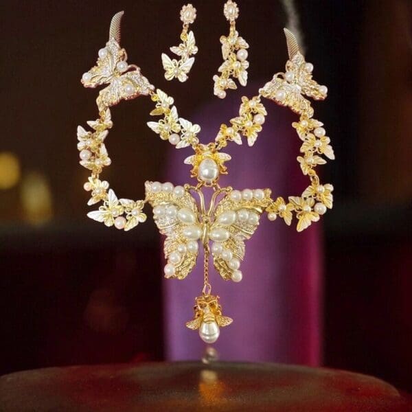 A butterfly necklace and earrings set on top of a table.