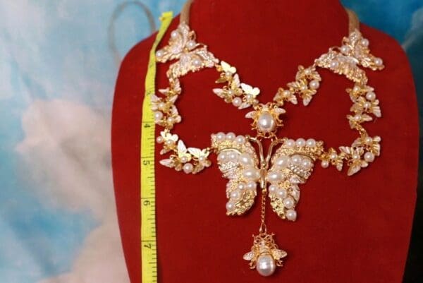 A red velvet display with a butterfly necklace and earrings.