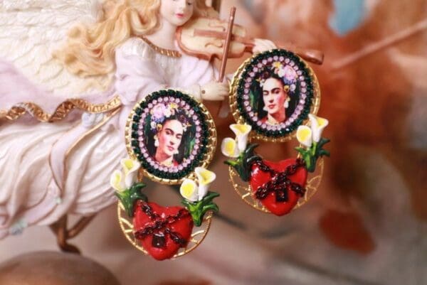 A pair of earrings with a picture of frida kahlo.