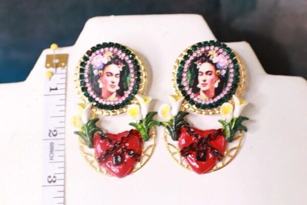 A pair of earrings with frida kahlo on it.