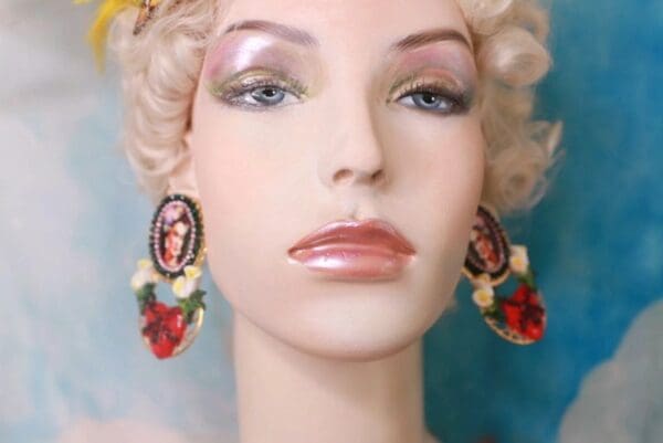 A mannequin with blonde hair and red earrings.