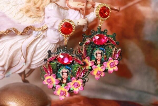 A pair of earrings with flowers and a woman 's face.
